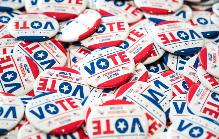 A close-up of numerous "Vote" buttons promoting the United States of America presidential election