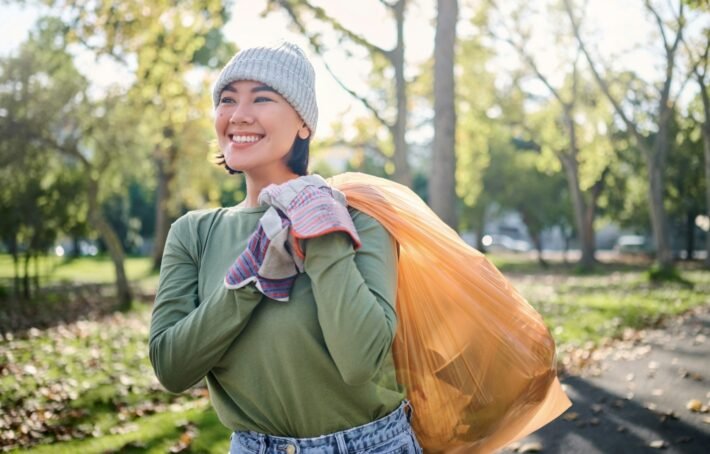 Plastic bag, park and woman cleaning in eco friendly, climate change or community service project f