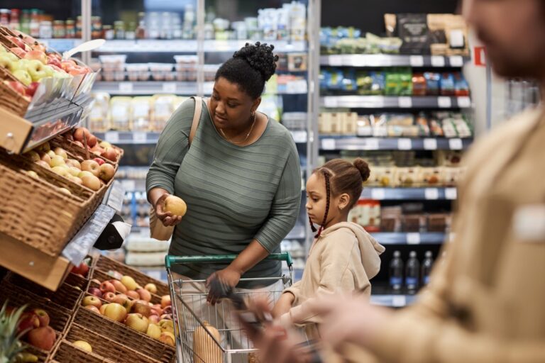 Black young woman with little girl shopping for groceries in supermarket